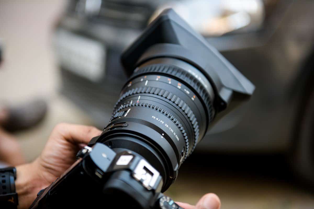 Fotograf drzi profesionalni fotoaparat u ruci.